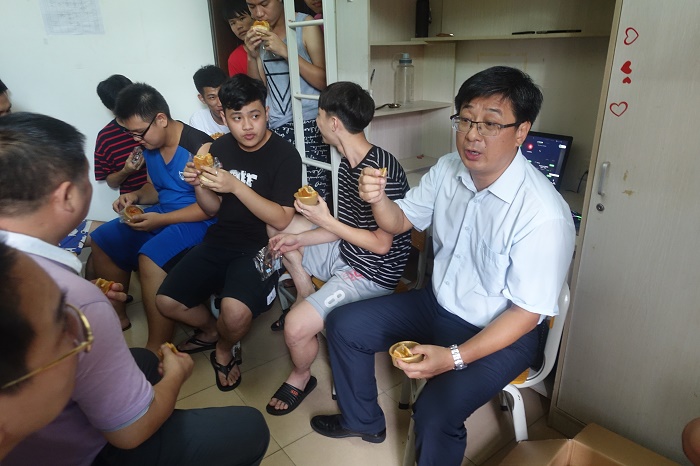 9月13日，王安兴与学生拉家常品尝月饼（宣传部 袁媛摄影）.JPG